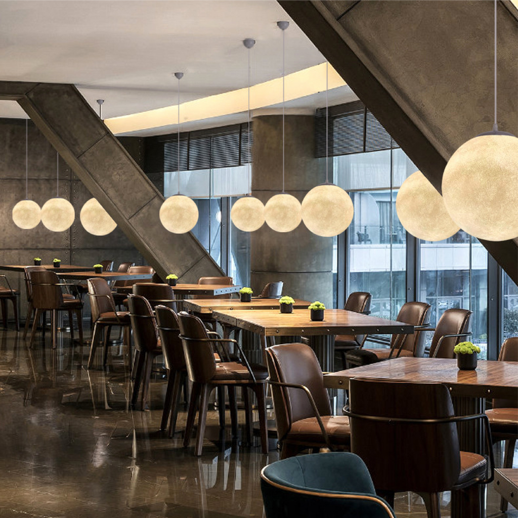 Moon pendant light glowing above dining table