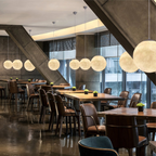 Moon pendant light glowing above dining table